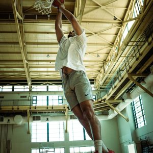A man dunking a basketball in a gym